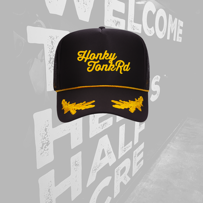 Black cap with yellow text and graphics on a gray background